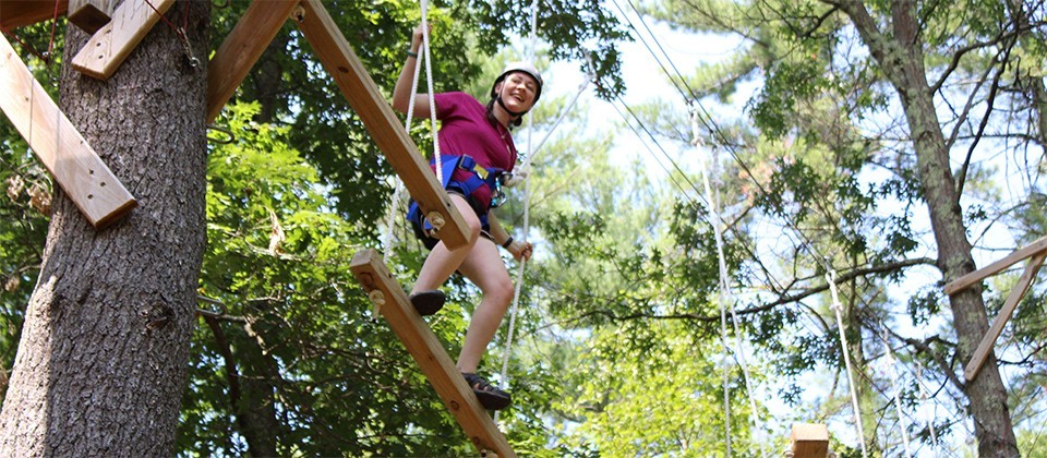 A Girl Scout on a high ropes course at camp