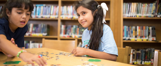 A smiling Girl Scout using a laptop at home on a couch