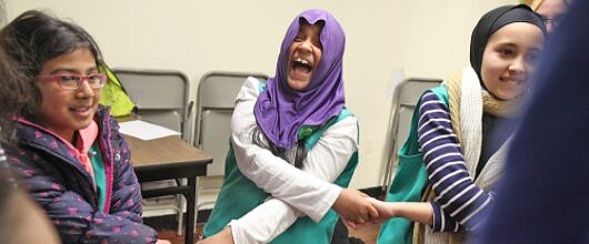 Three Girl Scouts laughing and holding hands