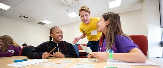 Two Girl Scouts with a GSEMA program partner leader