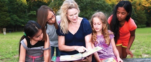 Volunteer reading to girls