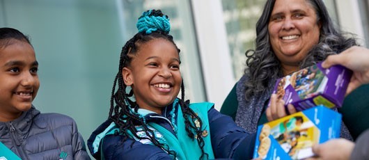 Girl Scouts holding cookie boxes